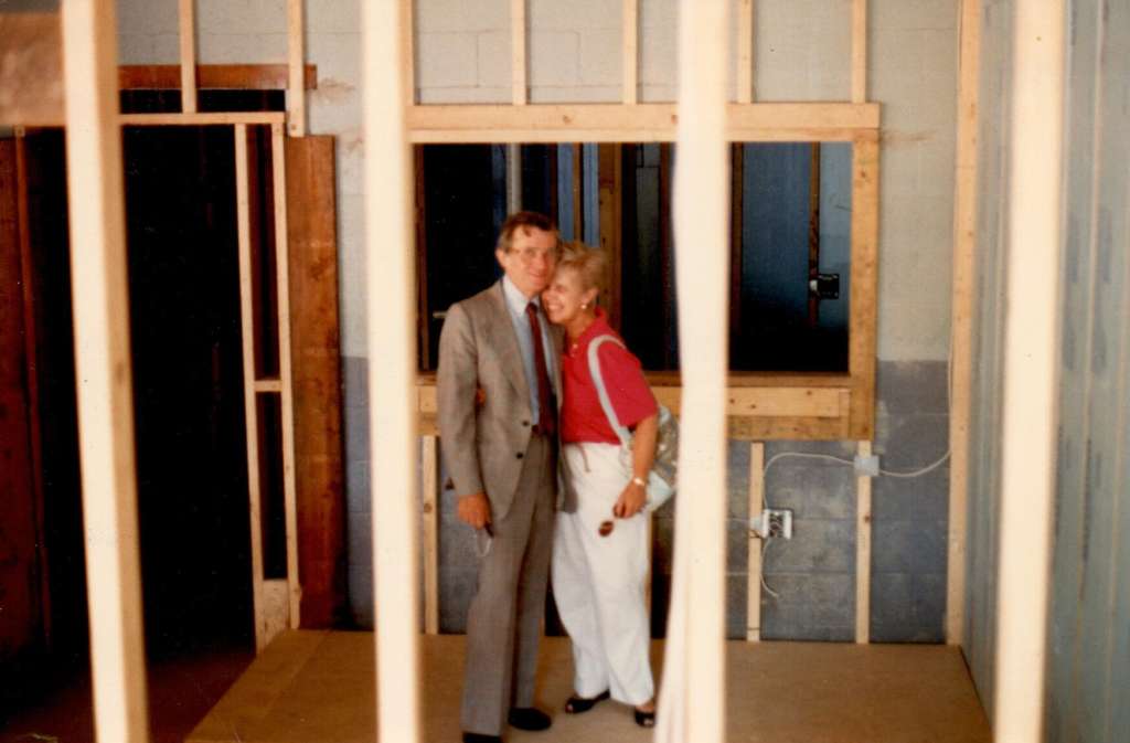 Jerome J. Scherer and wife Mary Ann Scherer standing between wood beams during construction of the new jewelry store in Amherst NY