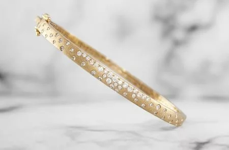yellow gold bangle bracelet with flush set diamonds